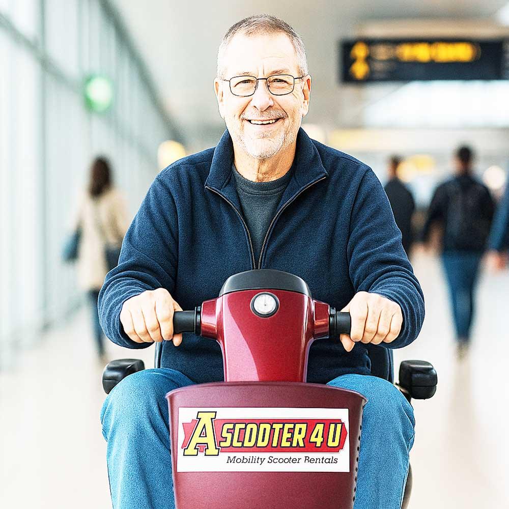 man riding a mobility scooter through an airport